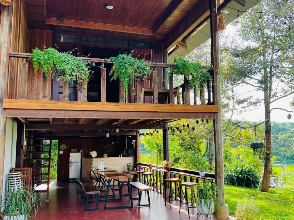 a house with a balcony with tables and chairs at May Garden Pleiku Homestay in Plei Hơlăng