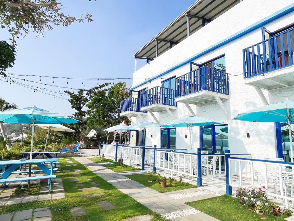 南灣的住宿－黃金海岸36海景旅店，前面有蓝色桌子和遮阳伞的建筑