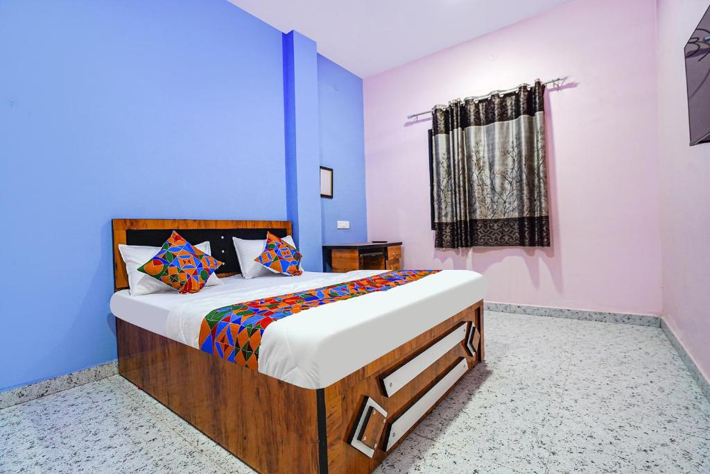 1 dormitorio con 1 cama en una habitación azul en FabExpress Evaan Deluxe Rooms, en Nagpur