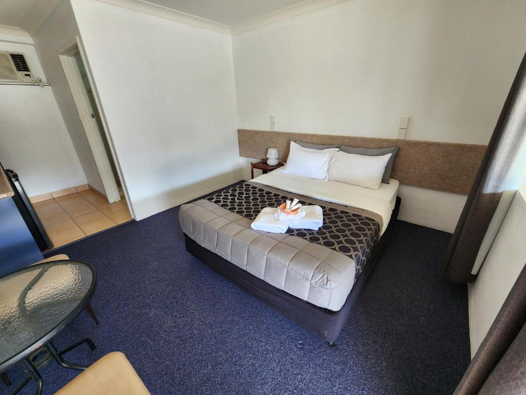 a hotel room with a bed and a chair at Nanango Star Motel in Nanango