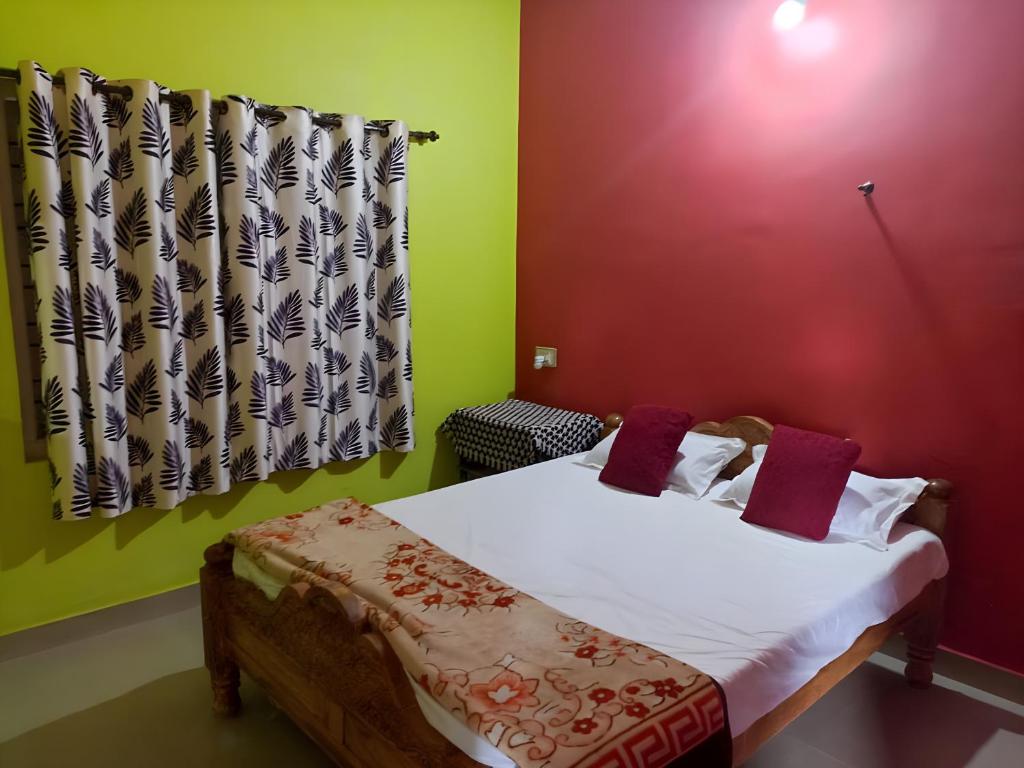 a bedroom with a bed with white sheets and red walls at Coorg Mists in Madikeri