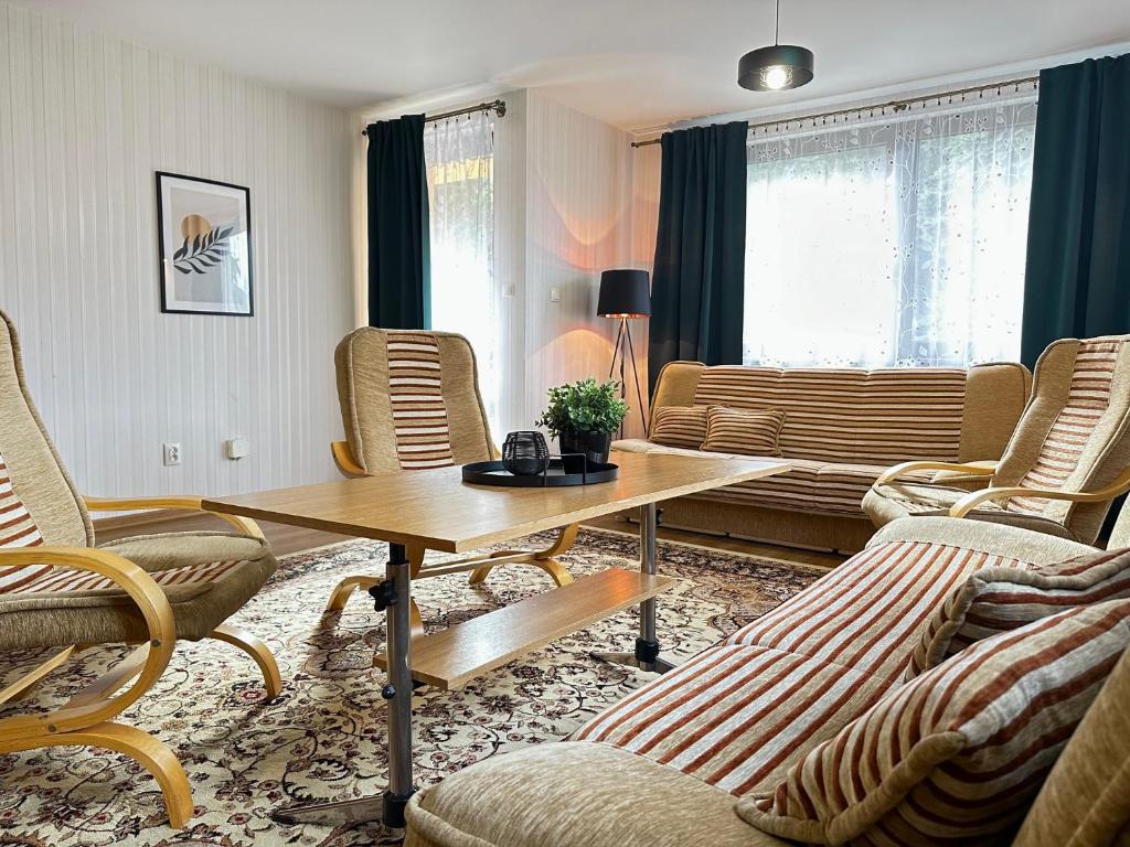ein Wohnzimmer mit Stühlen und einem Holztisch in der Unterkunft Ponikiew Resort in Wadowice