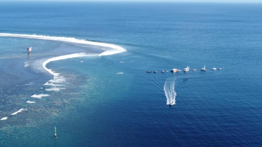 un'isola nell'oceano con barche in acqua di Maui Homestay a Tohautu