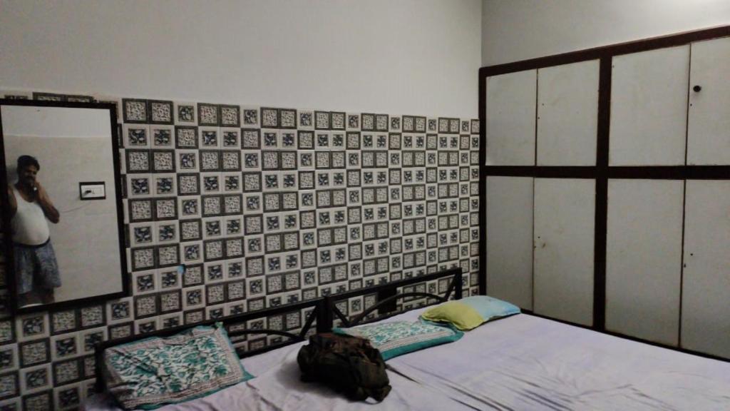 PrayagrajにあるSonu Bhawan Banquets Prayagrajのベッドルーム1室(ベッド1台付)、壁に鏡が備わります。