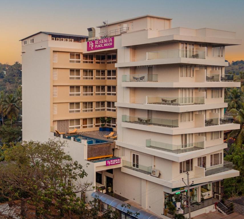 d'un grand bâtiment blanc avec balcon. dans l'établissement Regenta Place Vasco Goa, à Marmagao