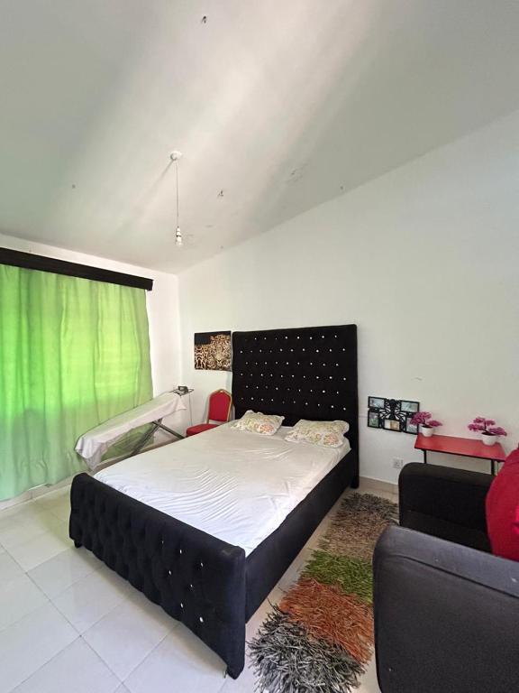 Mopearlz 4bedroom villa Nyali في مومباسا: غرفة نوم بسرير كبير وأريكة