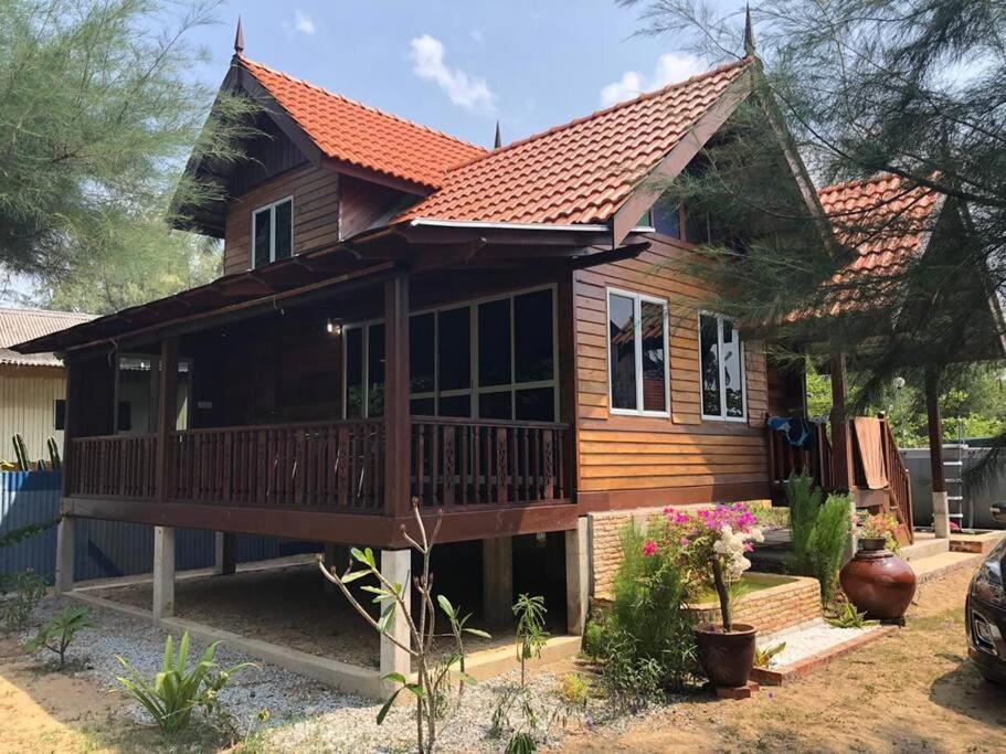 uma grande casa de madeira com um alpendre e varanda em Rumah D'Rhu, Zaki's Residence em Marang