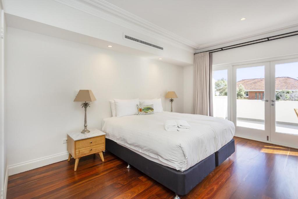a bedroom with a large bed and a large window at Cottesloe Aqua Retreat - Executive Escapes in Perth