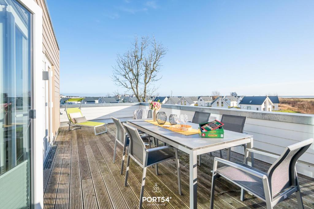 a patio with a table and chairs on a balcony at Ferienwohnung Küstenliebe Olpenitz in Olpenitz