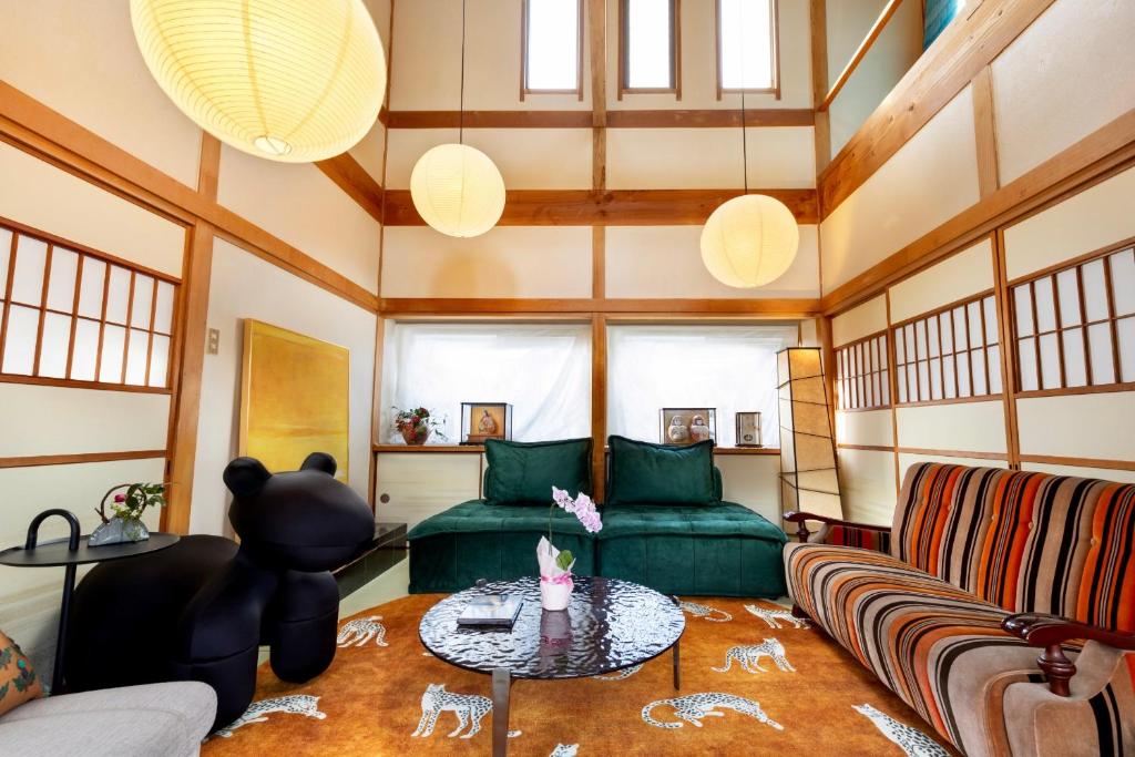 een woonkamer met een groene bank en een tafel bij 小景湯布院 in Yufu
