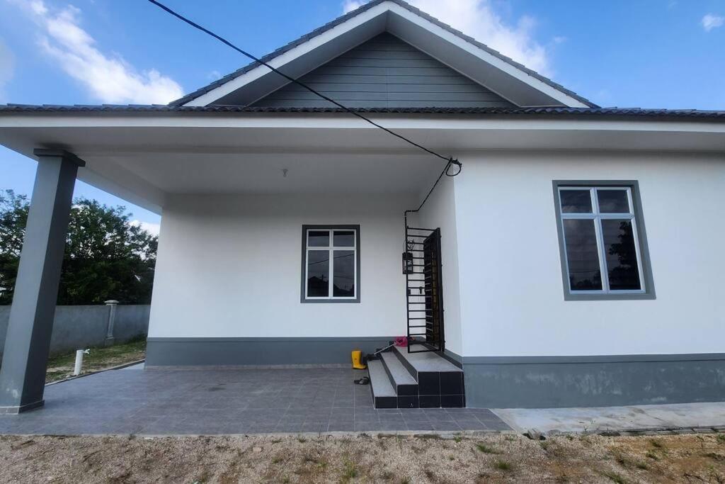 Casa blanca con porche y escaleras en Astaka Homestay Kok Lanas, en Ketereh