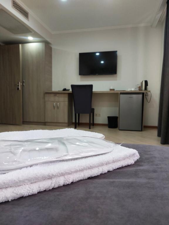 een slaapkamer met een wit bed en een flatscreen-tv bij Aparan Hotel in Aparan