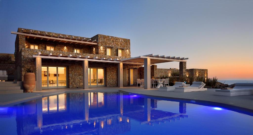 a house with a swimming pool in front of it at Mykonos Rocks Villas & Suites in Mikonos