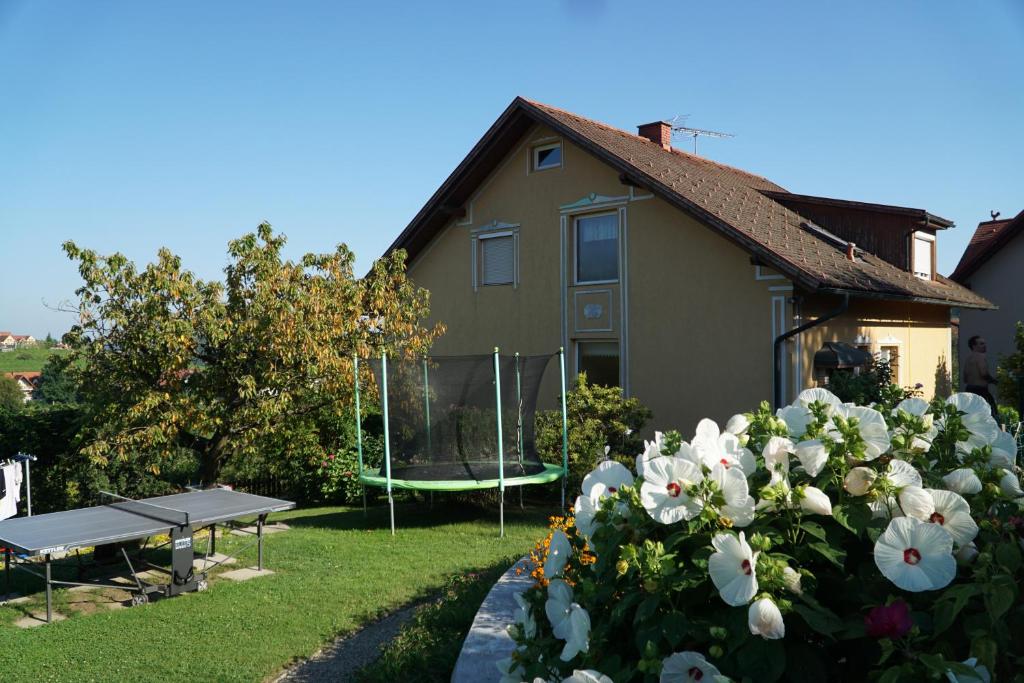 ein Haus mit einem Picknicktisch und Blumen im Hof in der Unterkunft Ferienwohnung Familie Hartinger in Riegersburg