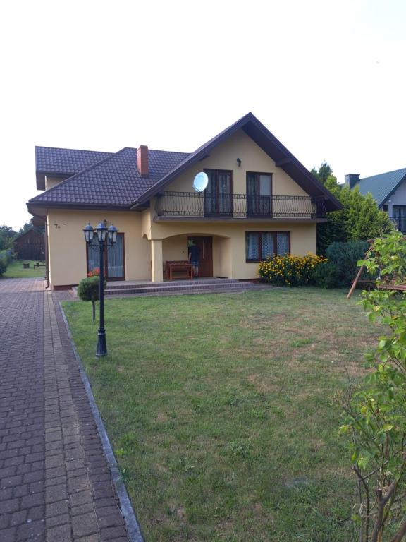 a house with a grass yard in front of it at Agroturystyka Pod Płaczącym Kamieniem in Józefów