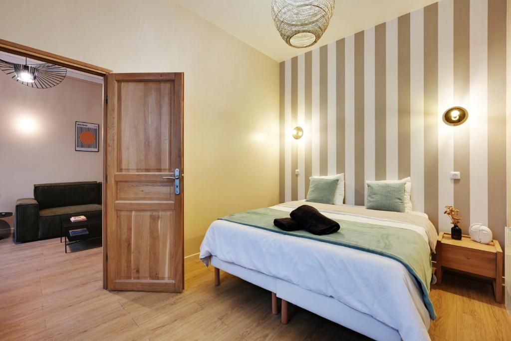 une chambre avec un lit et une chaise dedans dans l'établissement Charming Flat, quartier latin with a private cinema, à Paris