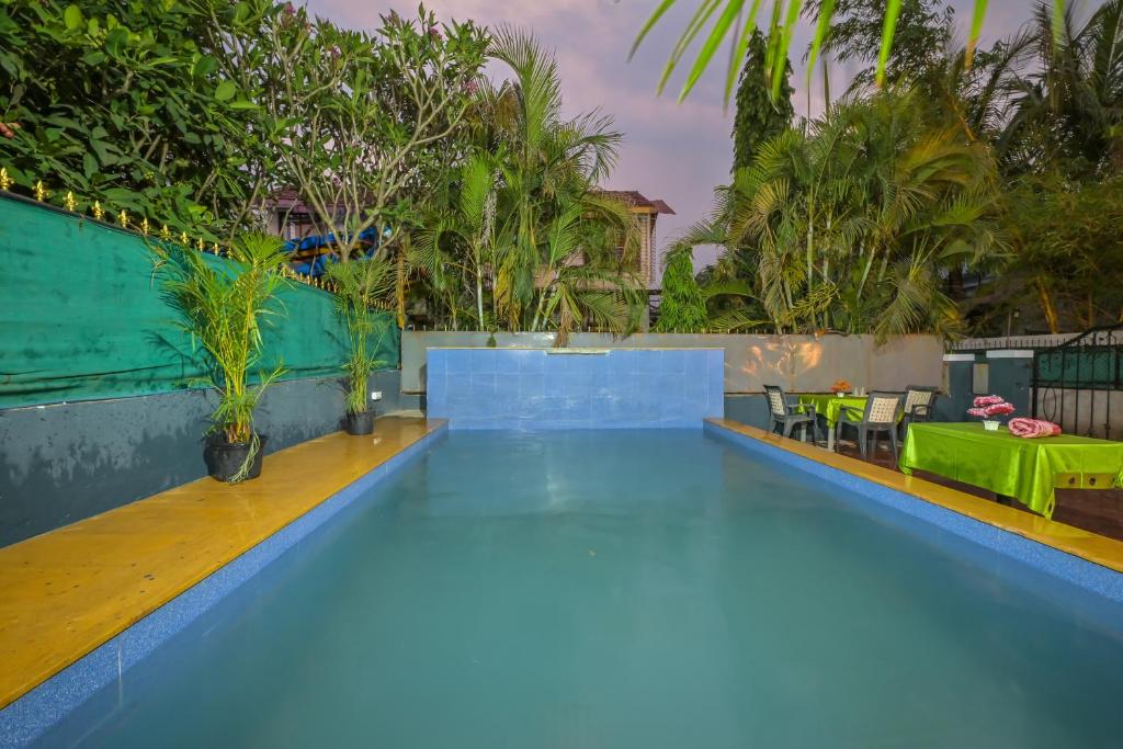 a large swimming pool with blue water and trees at EMPYREAN STAY II 2BHK II AC II POOL II SANAM VILLA ll in Lonavala