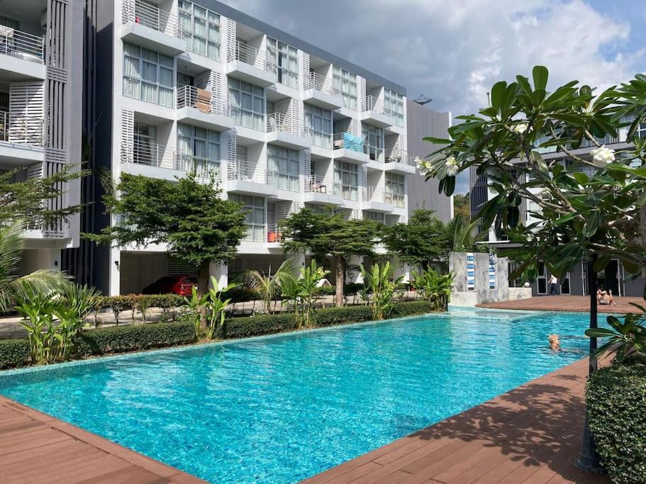 a swimming pool in front of a building at Chez Wanida - apartment Krabi in Klong Muang Beach