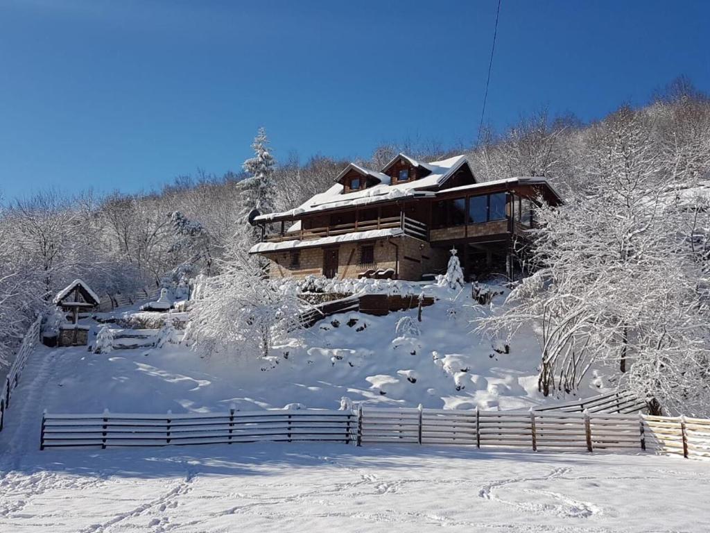 une cabane en rondins dans la neige avec une clôture dans l'établissement Planinska kuća HIL - Bjelašnica, à Sarajevo