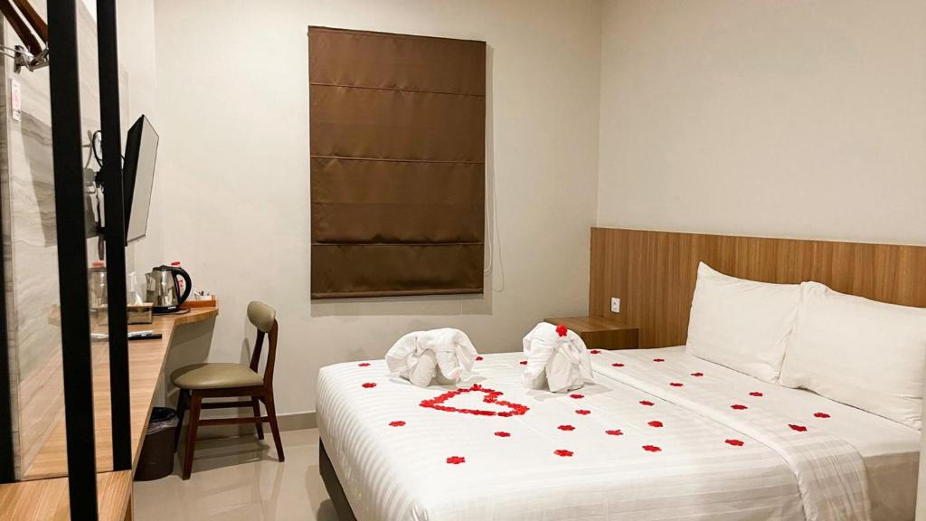 - une chambre avec un lit doté de coeurs rouges dans l'établissement Front One Hotel Gombong, à Gombong