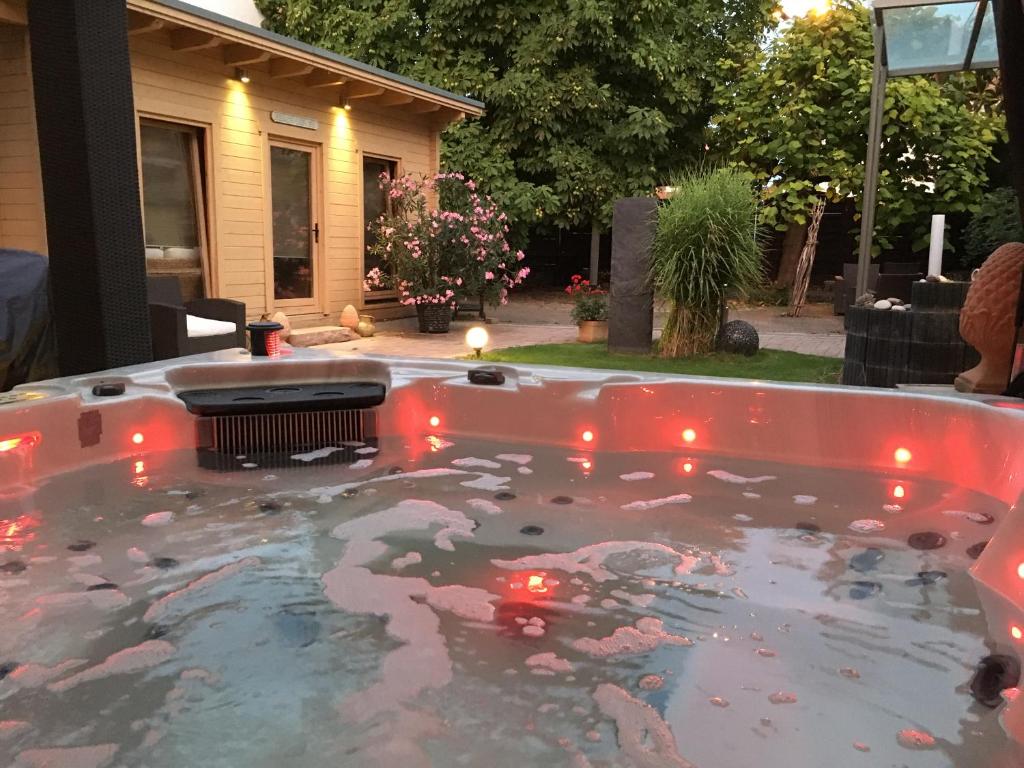 a hot tub with red lights in a yard at Hotel Schützenhof mit Klimaanlage in Bürstadt