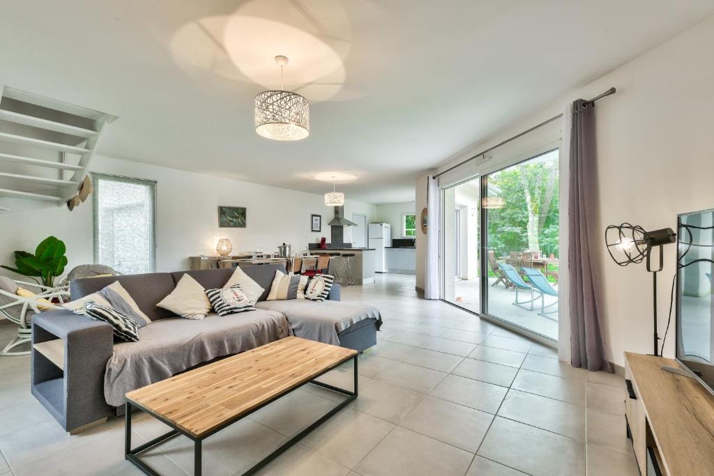 un salon avec un canapé et une table dans l'établissement Détente piscine à 150m de la plage à Arès, à Arès