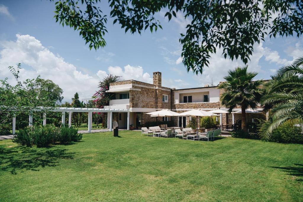 an exterior view of a house with a lawn at Lanthia Resort in Santa Maria Navarrese