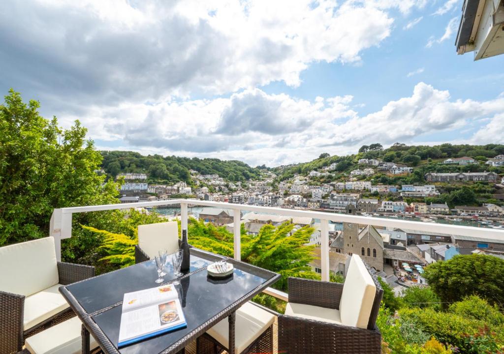 uma varanda com uma mesa e cadeiras e uma vista em Mizzen Cottage em Looe