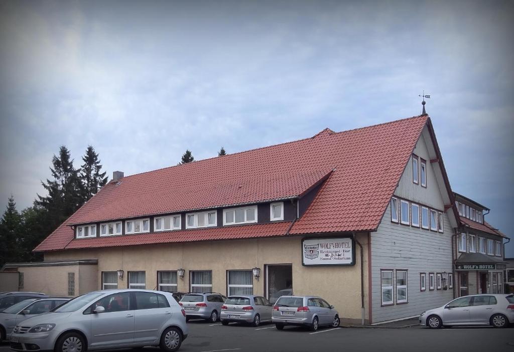 ein großes Gebäude mit davor geparkt in der Unterkunft Wolfs Hotel in Clausthal-Zellerfeld