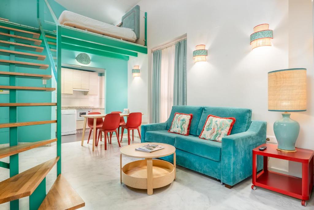 a living room with a blue couch and a table at Smartr Sevilla Las Dueñas in Seville
