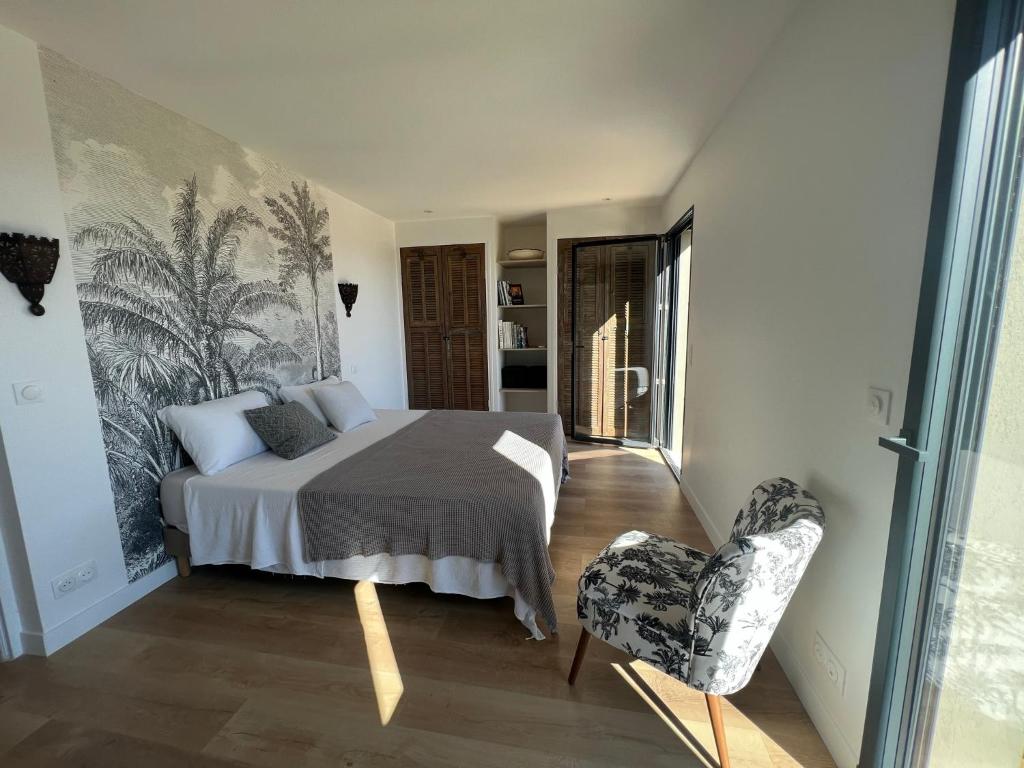 1 dormitorio con 1 cama y 1 silla en Villa Nomade proche de Cannes, en Vallauris