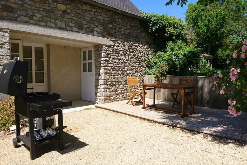 ceglany dom z grillem i drewnianym stołem w obiekcie Gîte Les Pommiers w mieście Montchaton