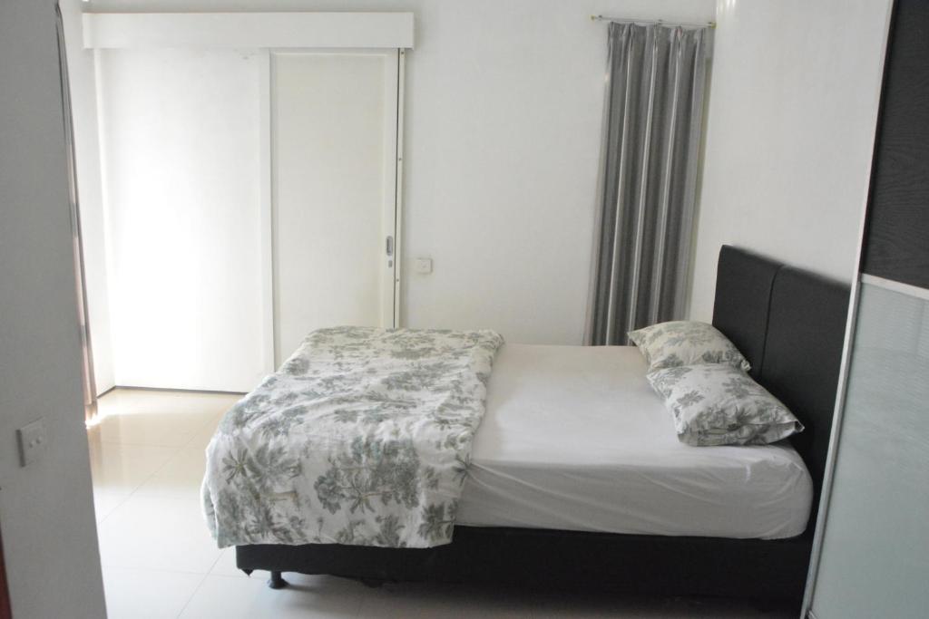 a bedroom with a bed with a blanket and pillows at Bracha house in Legian