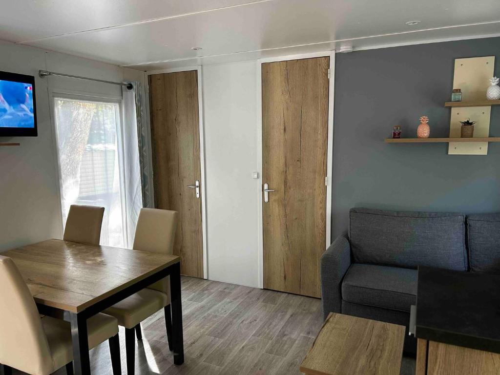 a small living room with a table and a chair at De La Terre Locan in Saint-Brevin-les-Pins