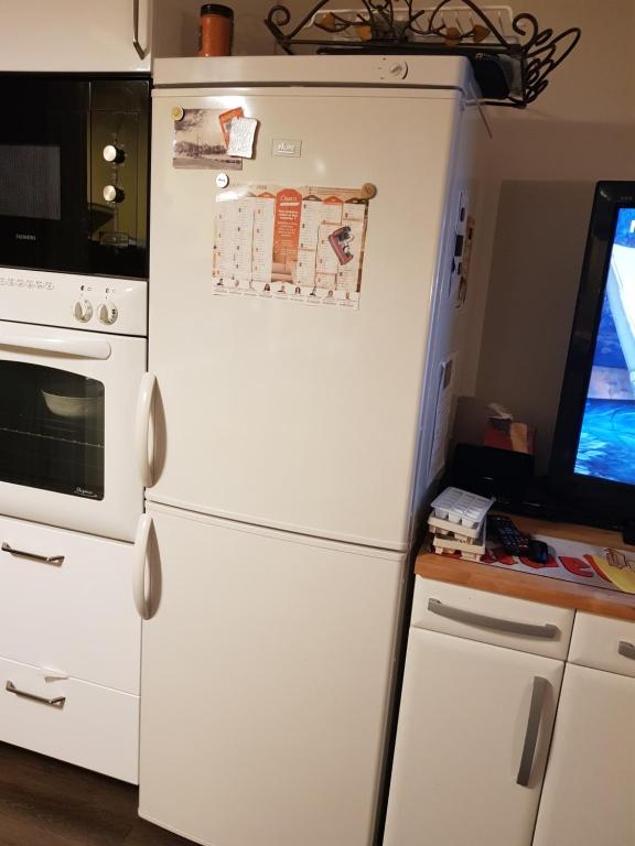 - un réfrigérateur blanc dans une cuisine à côté d'une fenêtre dans l'établissement Port plage a pied 3nuits mini, au Pouliguen