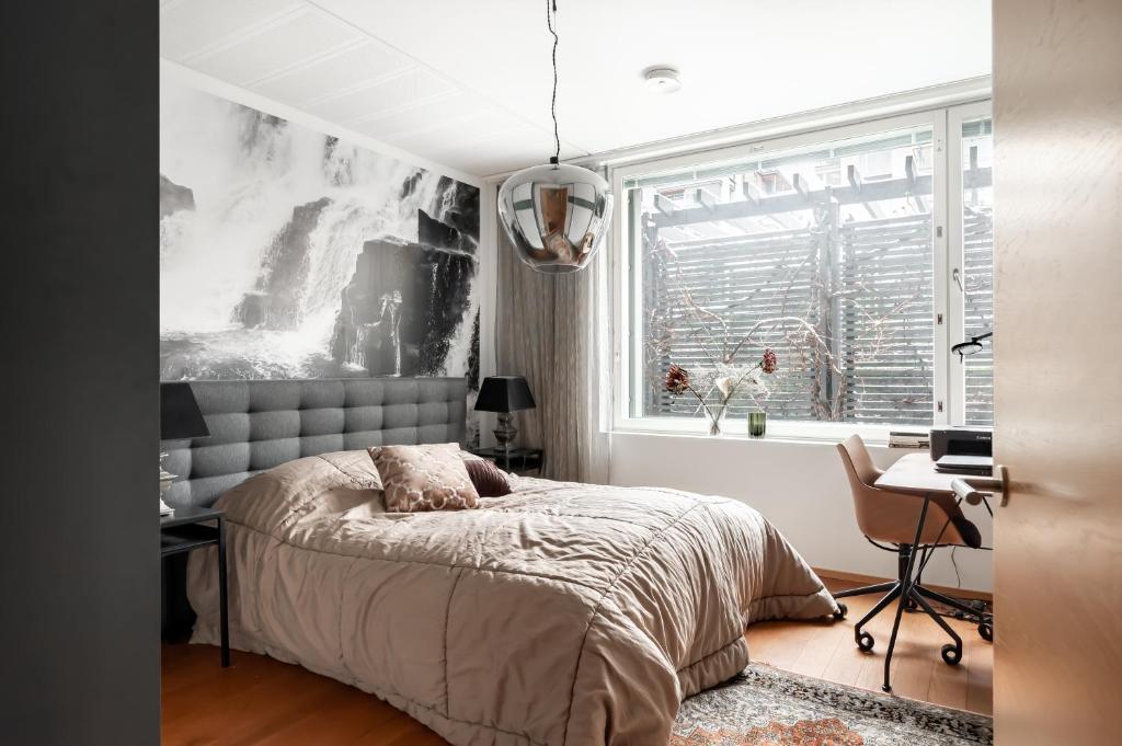 a bedroom with a bed and a desk and a window at Luxorius apartment on the beach and the citycenter in Helsinki