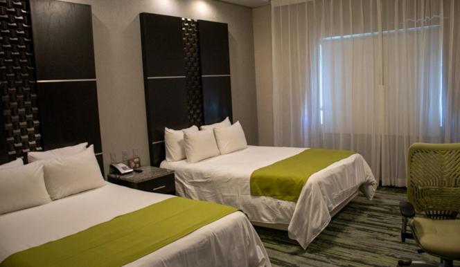 A bed or beds in a room at Hotel Araiza San Luis R.C.