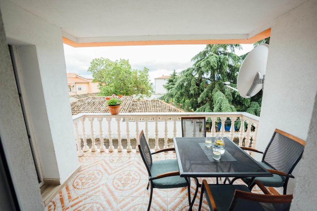 a balcony with a table and chairs on a balcony at Lenić apartman in Fažana