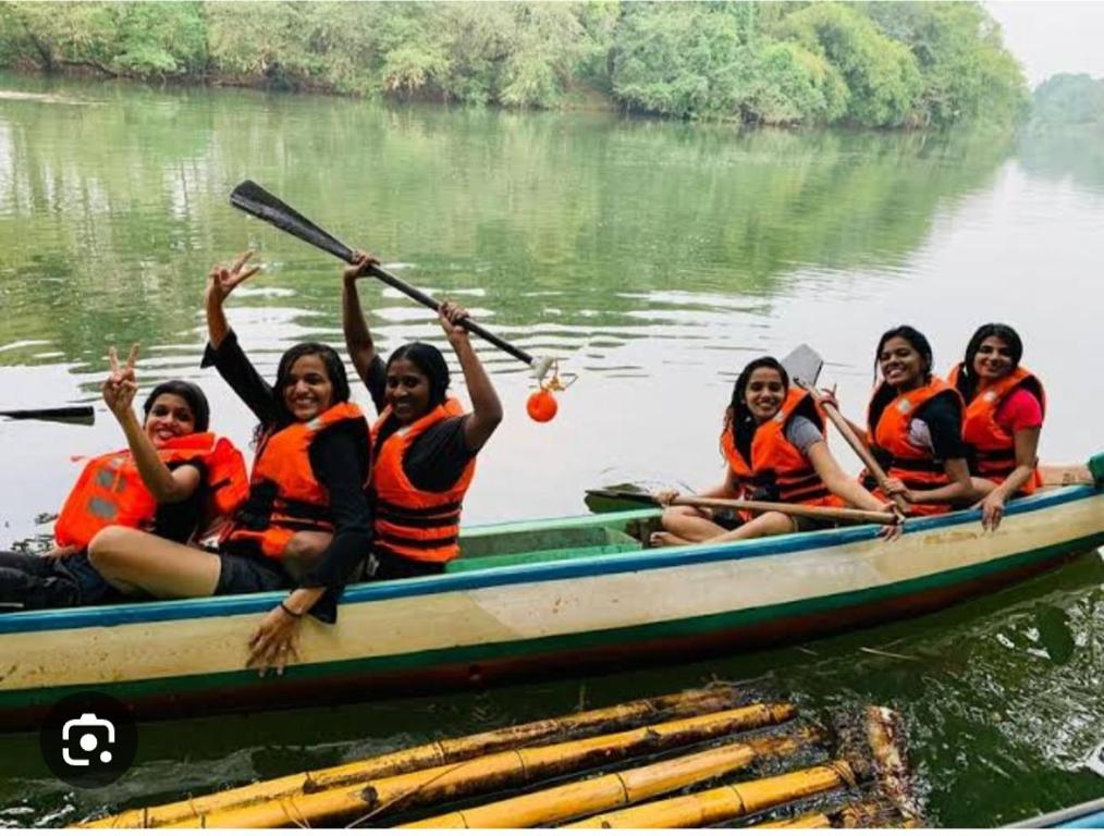 a group of women in a boat on the water at AMBAT HOMESTAY in Kottayam