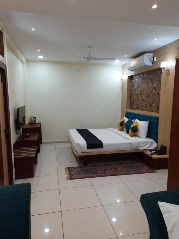 a hotel room with a bed and a desk at Hotel Sarika International in Indore