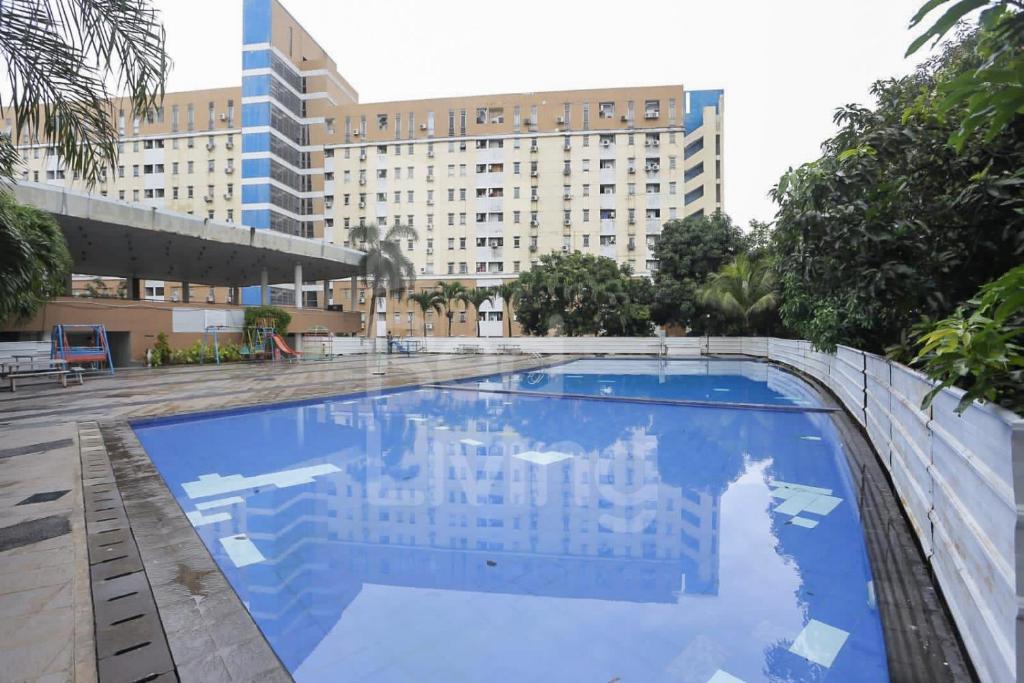 une grande piscine en face d'un bâtiment dans l'établissement RedLiving The Golf Apartement Modernland - Maria Room Tower Red, à Buaran