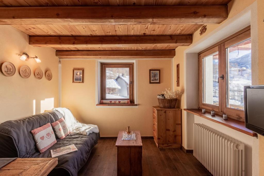 a living room with a couch and a table at HelloChalet - Duplex Maison Loz with balcony in Valtournenche