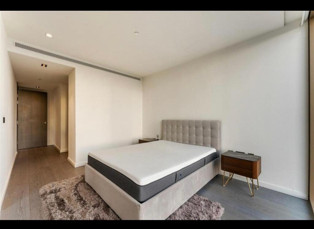 - une chambre avec un grand lit, une table et un tapis dans l'établissement Trendy, modern 2 bed apartment!, à Londres