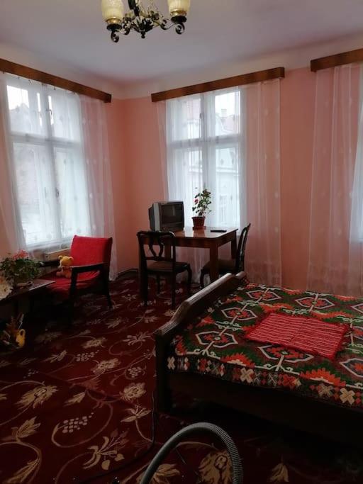 une chambre avec un lit, une table et des fenêtres dans l'établissement La 2 pași de Biserica Neagră, à Braşov