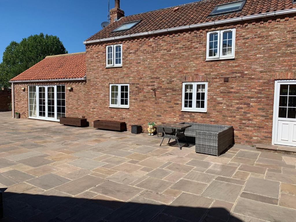 a patio in front of a brick building at Bumblebee Cottage in Skipsea