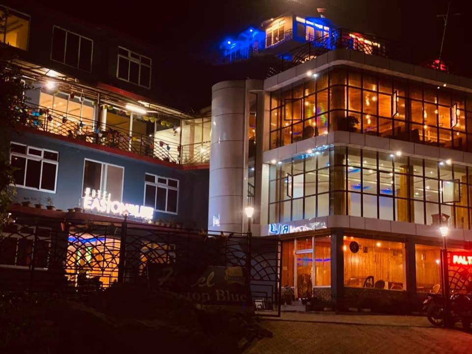 a building with blue lights on it at night at East On Blue Hotel in Ilām