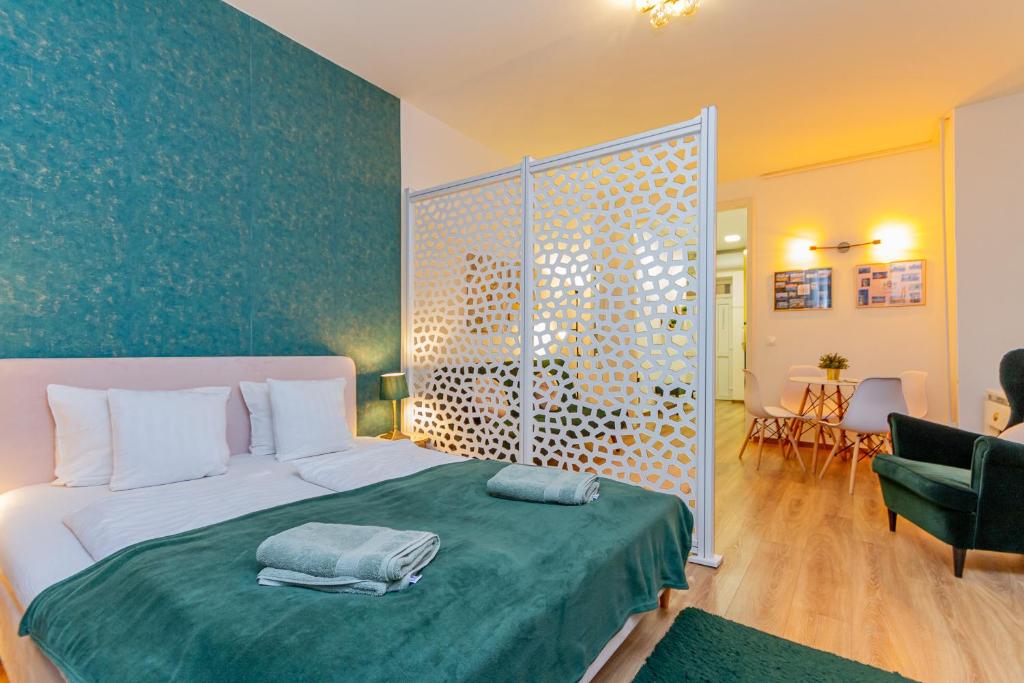 1 dormitorio con 1 cama grande con manta verde en RothApartments'ALICE, en Budapest