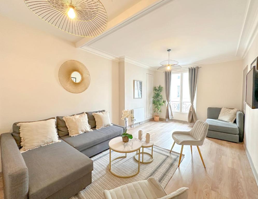 uma sala de estar com um sofá e uma mesa em Champs Elysées area - Deluxe Family Apartments em Paris