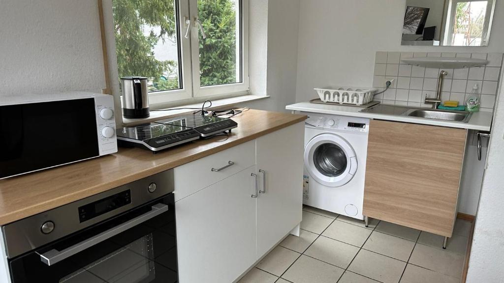 een keuken met een wasmachine en een magnetron bij Jonagold Unterkunft in Karlsruhe