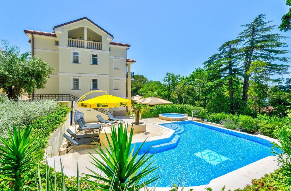 a villa with a swimming pool in front of a house at Nur 140 Meter zum Strand mit Pool in Crikvenica